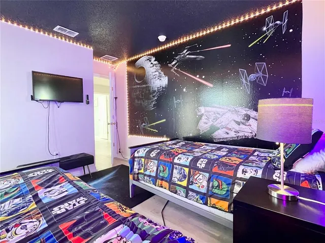 a bedroom with a bed and flat screen tv