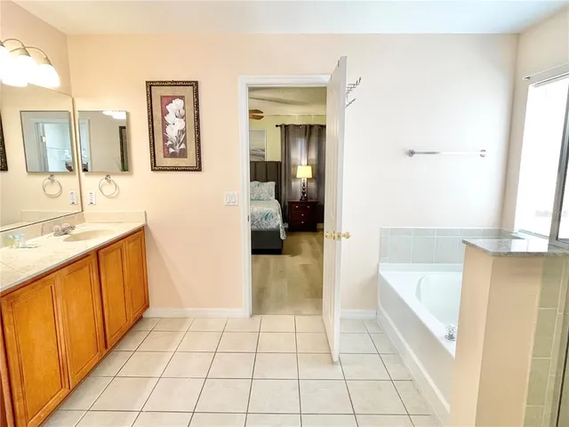 a bathroom with a tub a sink a mirror and a shower