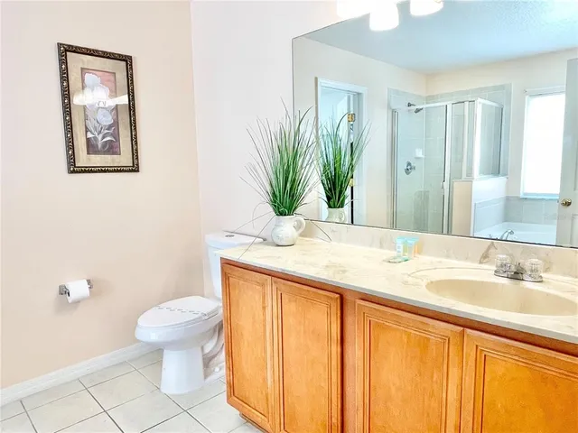 a bathroom with a granite countertop sink a toilet and mirror