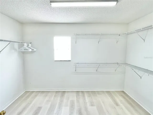 a view of a kitchen with white cabinets and wooden floor