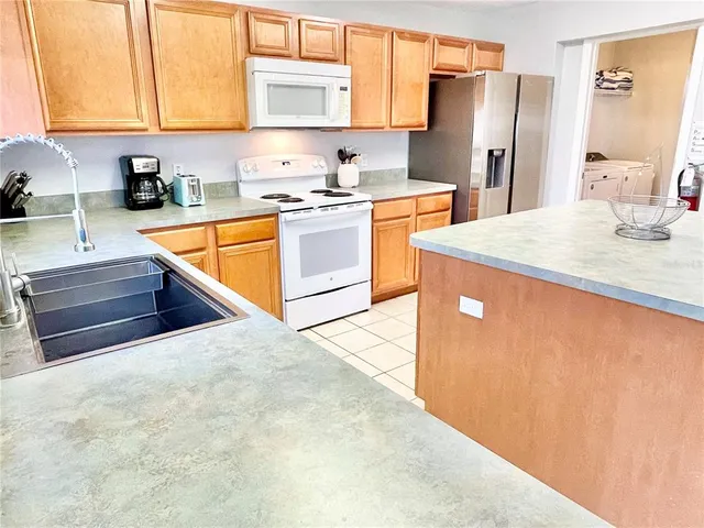 a kitchen with stainless steel appliances a sink a stove a refrigerator and cabinets