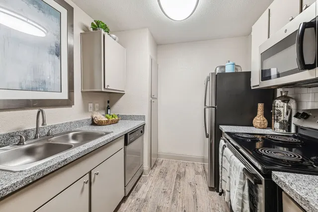 a kitchen with stainless steel appliances granite countertop a sink stove and refrigerator