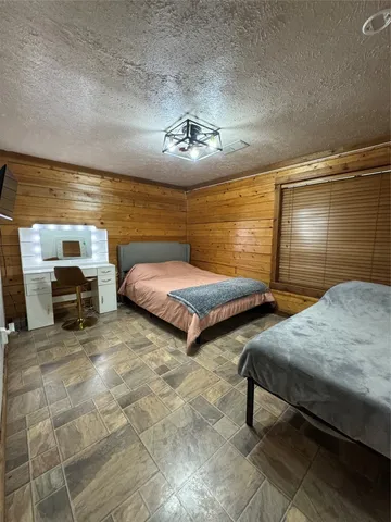 a spacious bedroom with a bed and wooden floor