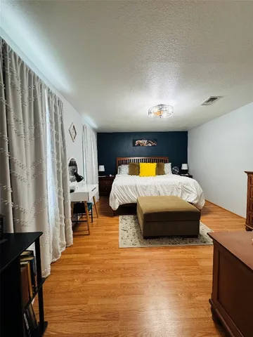 a bedroom with furniture and a flat screen tv
