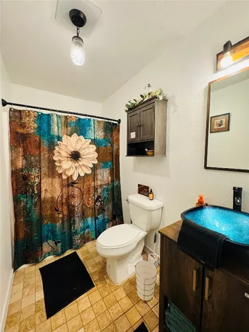 a bathroom with a sink mirror vanity and toilet