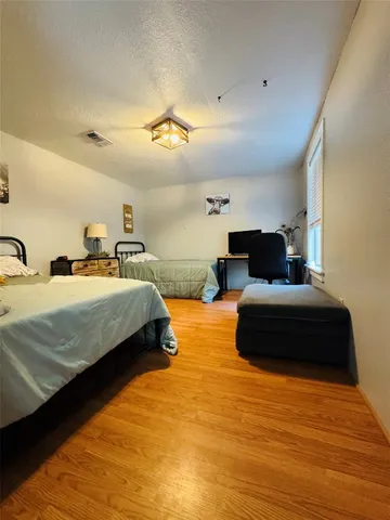 a bedroom with two beds and a potted plant on the dresser