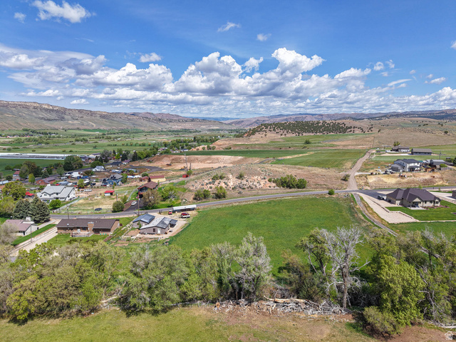 94 Spring Canyon Road Coalville, UT 84017 - Photo 21 of 50 Expansive property featuring verdant fields, established trees, and a distant mountain range backdrop