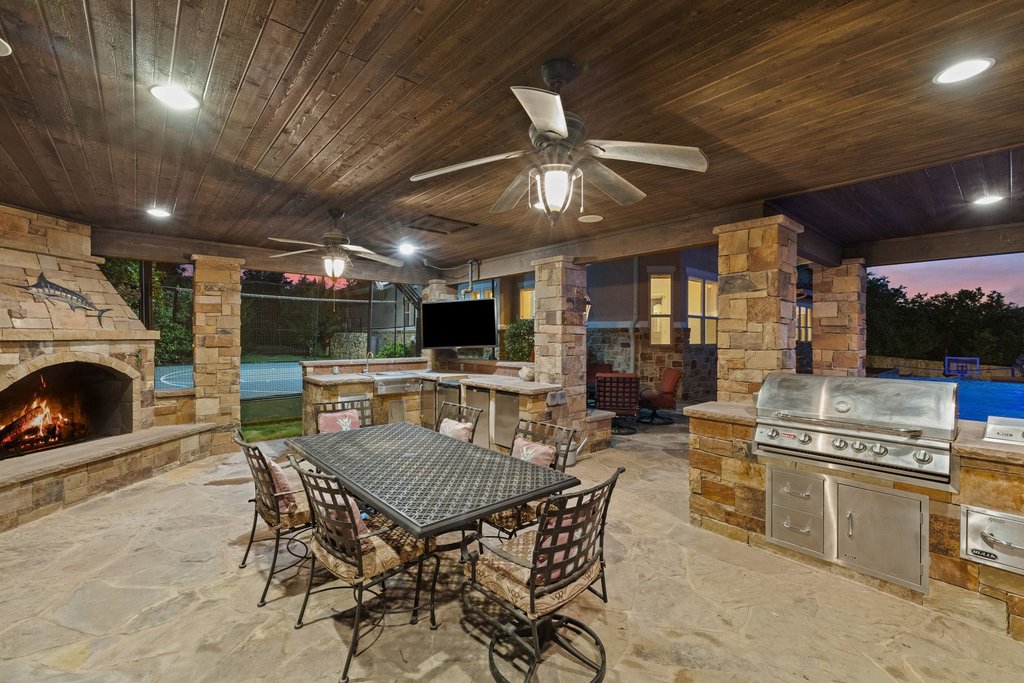 109 Largo Cove Austin, TX 78734 - Photo 36 of 40 An inviting outdoor living space features a cozy fireplace and a fully equipped built-in barbecue area.