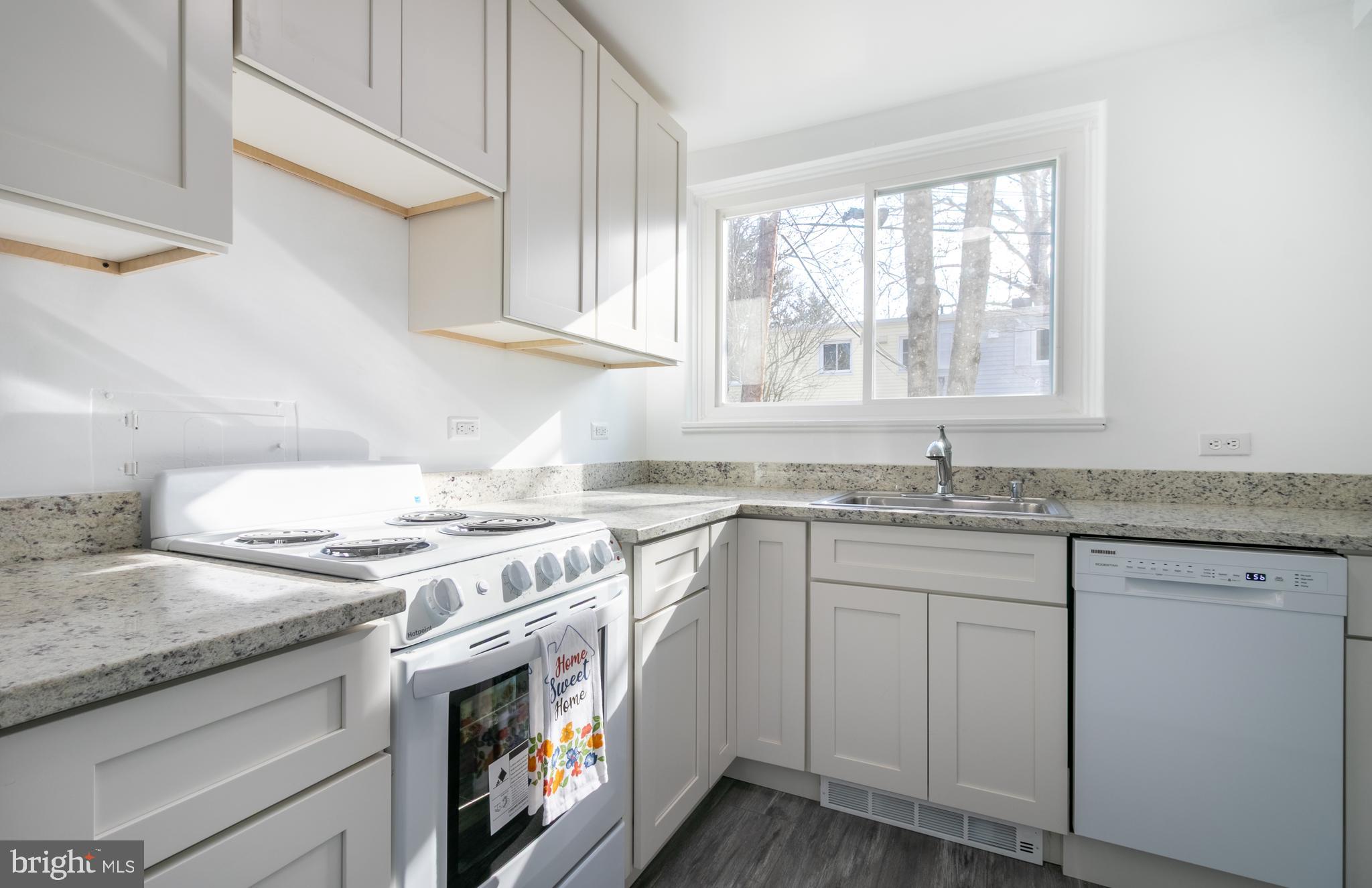 3 Ridge Road Greenbelt, MD 20770 - Photo 5 of 16 a kitchen with granite countertop a sink stove and cabinets
