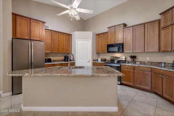 a kitchen with stainless steel appliances granite countertop a refrigerator a stove top oven a sink and dishwasher