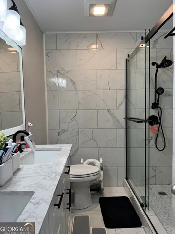 a bathroom with a sink a toilet and shower