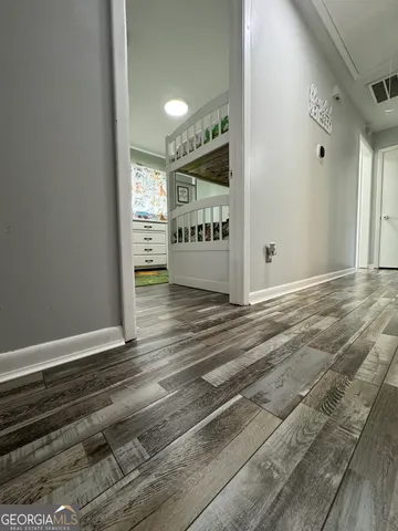 a view of a hallway with wooden floor and windows