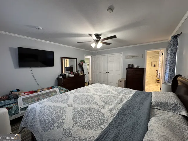 a bed room with a bed a television and a large mirror