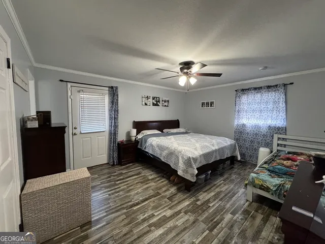 a bedroom with bed and wooden floor