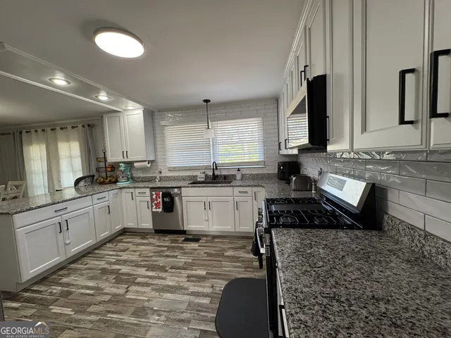 a large white kitchen with cabinets