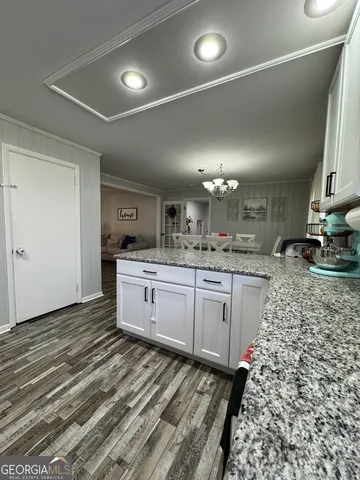 a kitchen with granite countertop a sink cabinets and stainless steel appliances