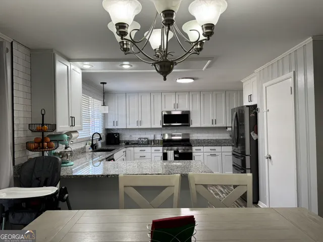 a kitchen with stainless steel appliances granite countertop a sink a stove and a refrigerator