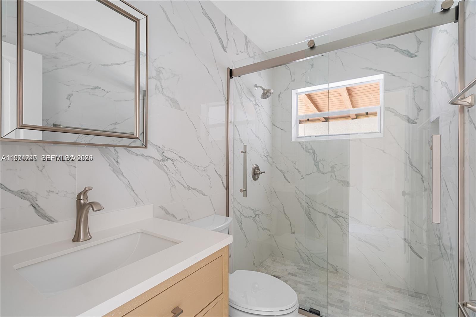 10700 Southwest 70th Street Miami, FL 33173 - Photo 11 of 19 a bathroom with a sink a toilet and shower