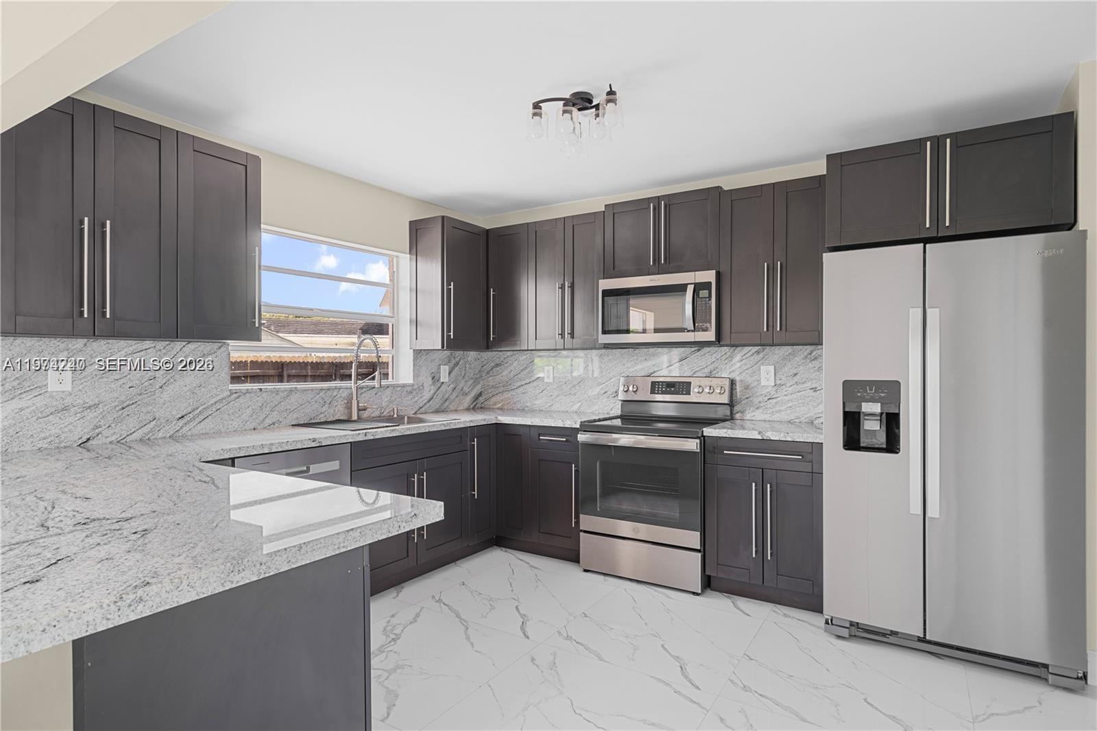 10700 Southwest 70th Street Miami, FL 33173 - Photo 8 of 19 a kitchen with stainless steel appliances granite countertop a refrigerator stove a sink and dishwasher