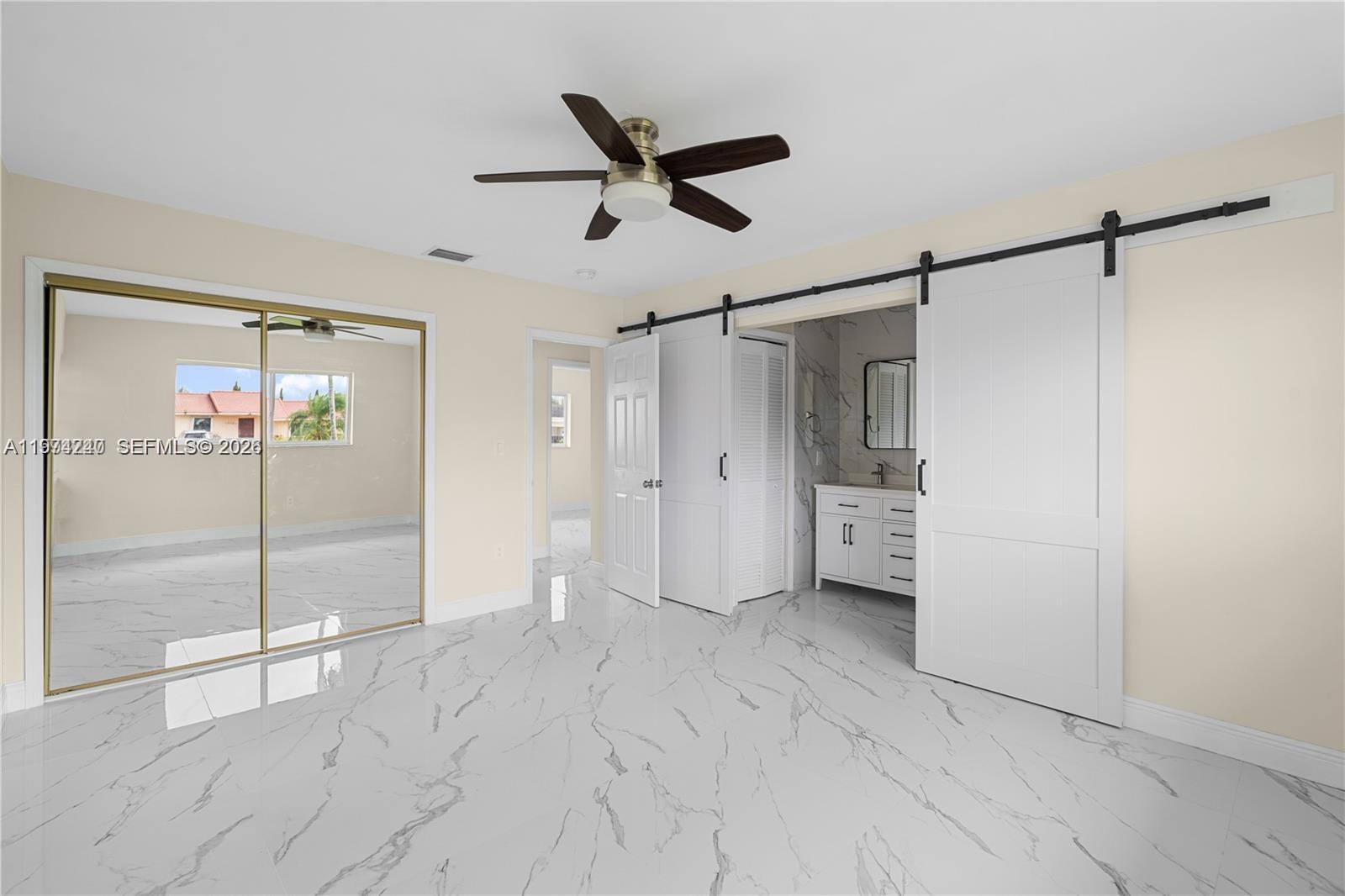 10700 Southwest 70th Street Miami, FL 33173 - Photo 10 of 19 a view of empty room with wooden floor and windows