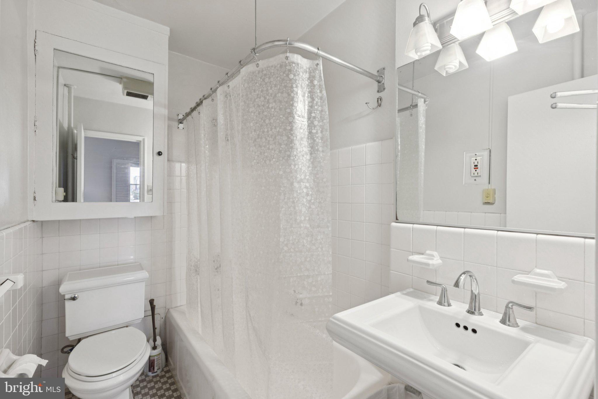 2601 Pennsylvania Avenue, Unit 848 Philadelphia, PA 19130 - Photo 10 of 12 a bathroom with a sink a mirror and a toilet