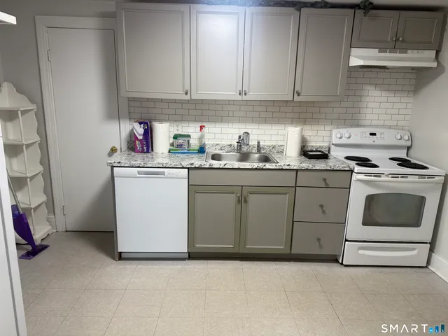 a kitchen with white cabinets and white appliances