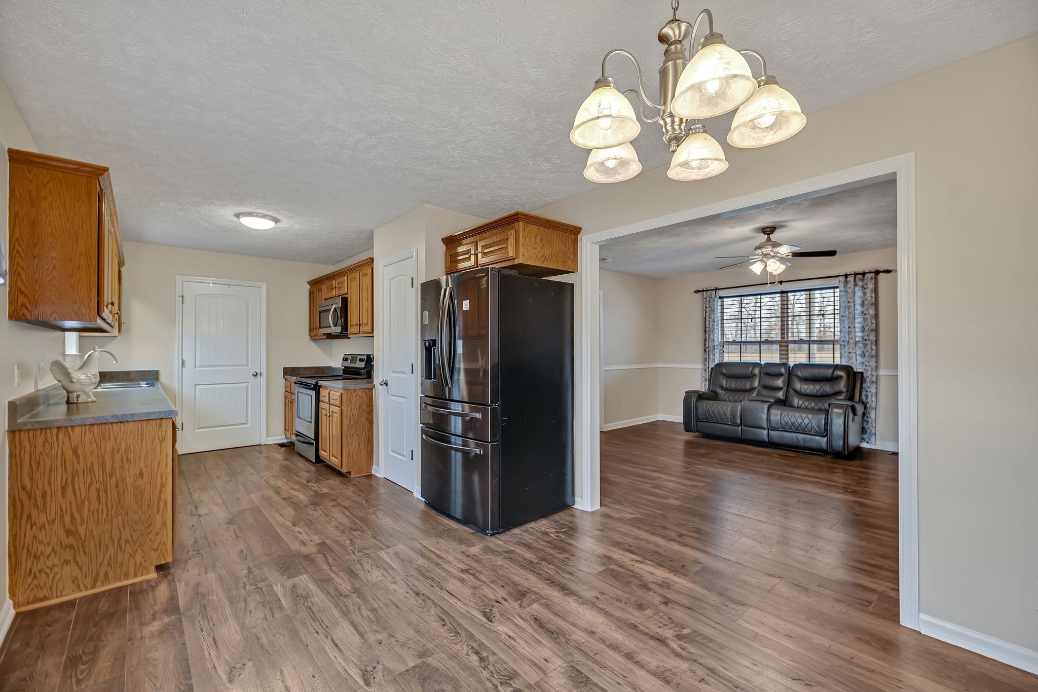 153 Spry Road Morrison, TN 37357 - Photo 4 of 19 a view of a kitchen with a sink dishwasher a refrigerator with wooden floor and cabinets