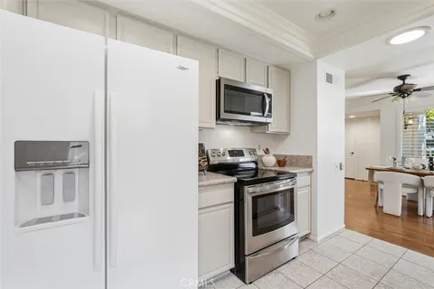 a kitchen with stainless steel appliances granite countertop white cabinets a stove top oven