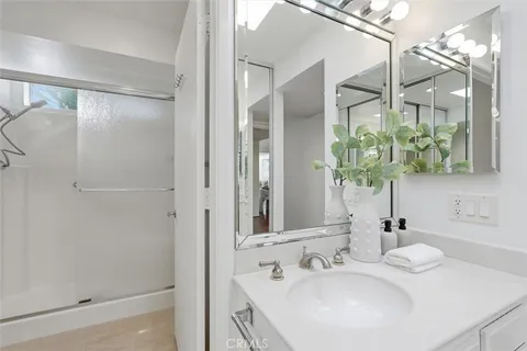 a bathroom with a double vanity sink mirror and shower