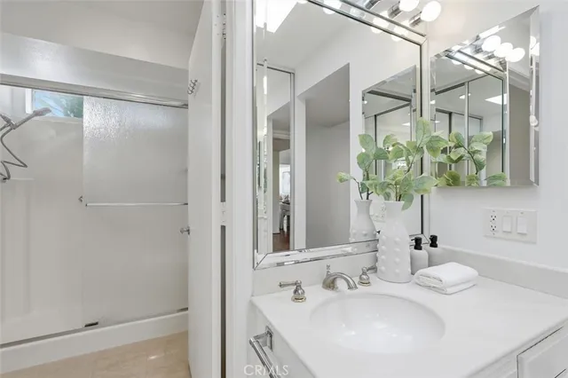 a bathroom with a double vanity sink mirror and shower