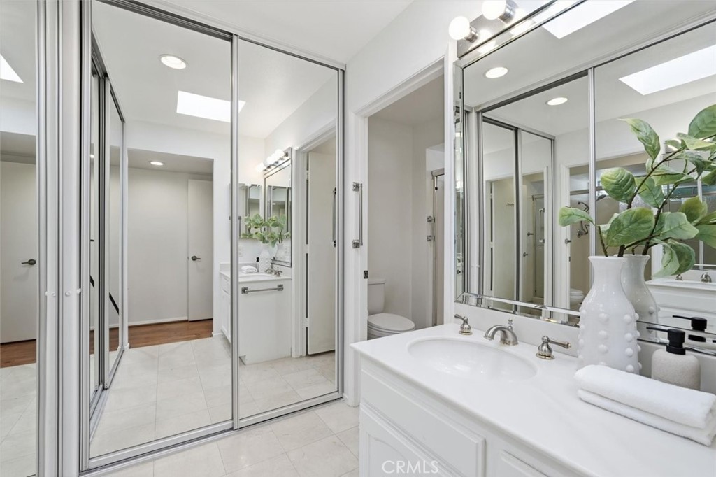 5512 West Paseo Del Lago, Unit C Laguna Woods, CA 92637 - Photo 27 of 45 a bathroom with a double vanity sink mirror and shower