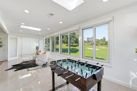 a living room with furniture a large window and wooden floor