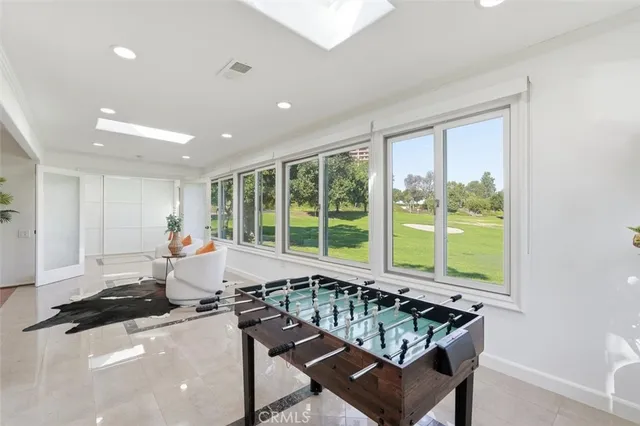 a living room with furniture a large window and wooden floor