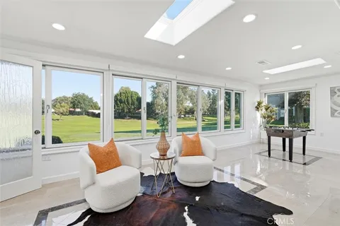 a living room with furniture and a large window with garden view