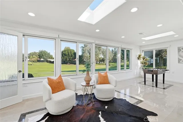 a living room with furniture and a large window with garden view