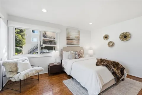 a view of a bedroom with wooden floor and a potted plant
