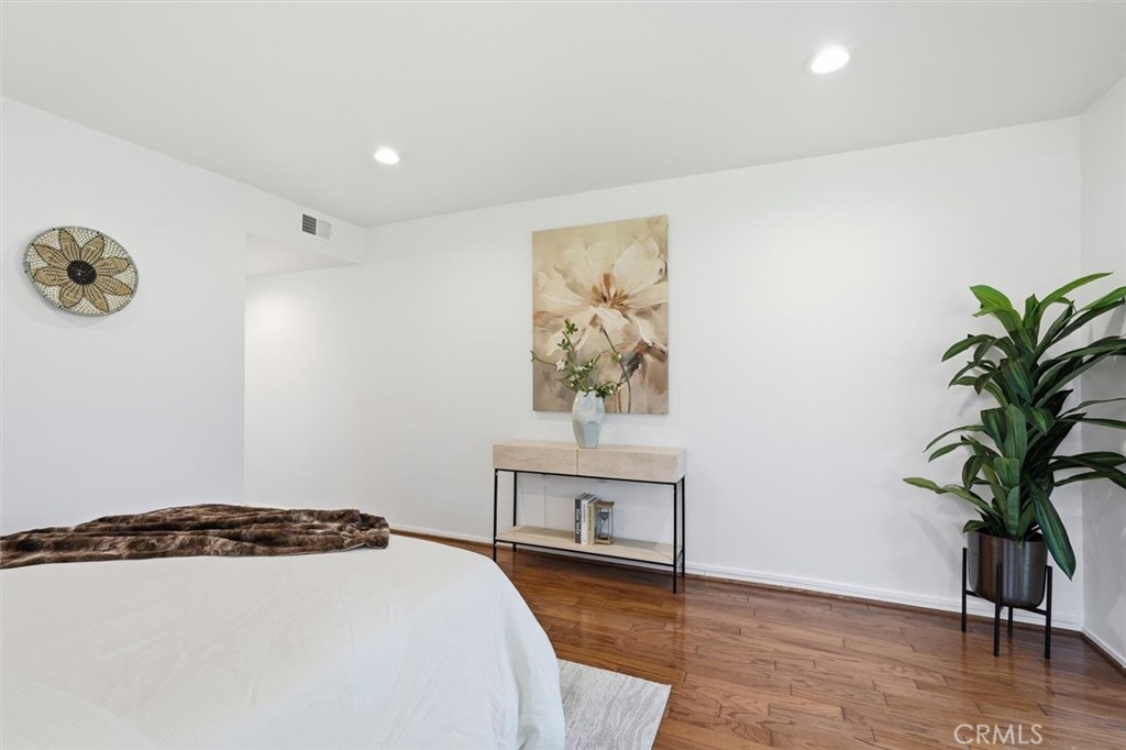 5512 West Paseo Del Lago, Unit C Laguna Woods, CA 92637 - Photo 32 of 45 a view of a bedroom with wooden floor and a potted plant