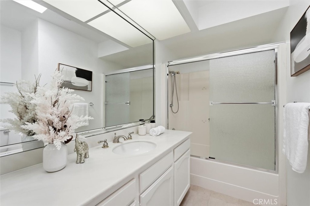5512 West Paseo Del Lago, Unit C Laguna Woods, CA 92637 - Photo 33 of 45 a bathroom with a granite countertop sink a mirror and shower