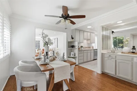 a kitchen with granite countertop a dining table chairs and white cabinets