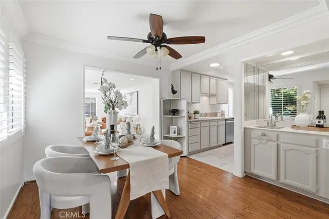 a kitchen with granite countertop a dining table chairs and white cabinets