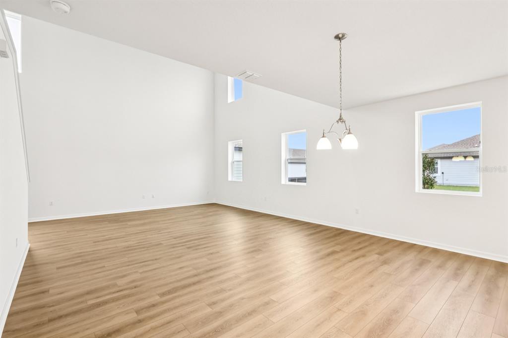 30158 Rustic Mill St Mount Mount Dora, FL 32757 - Photo 7 of 41 a view of an empty room with wooden floor kitchen and a window