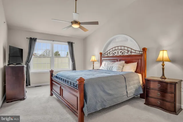 a bedroom with a bed and a flat tv screen on dresser