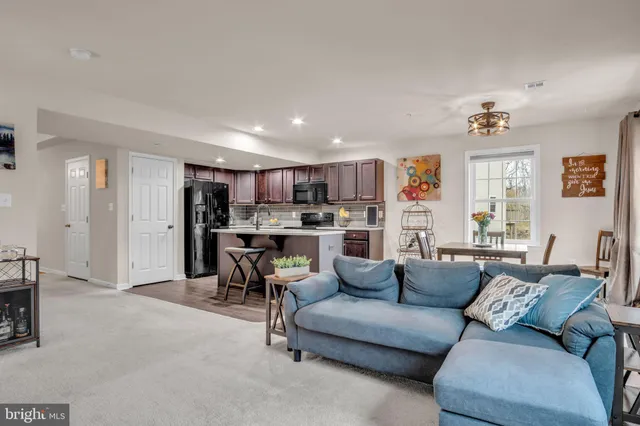 a living room with furniture and a kitchen view