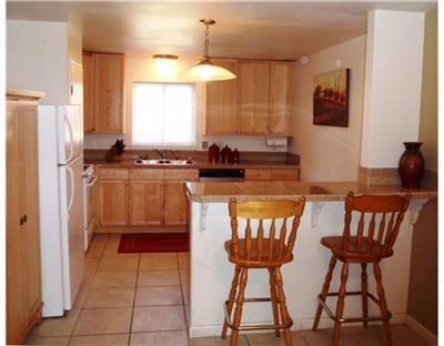 a kitchen with stainless steel appliances a dining table chairs and a refrigerator