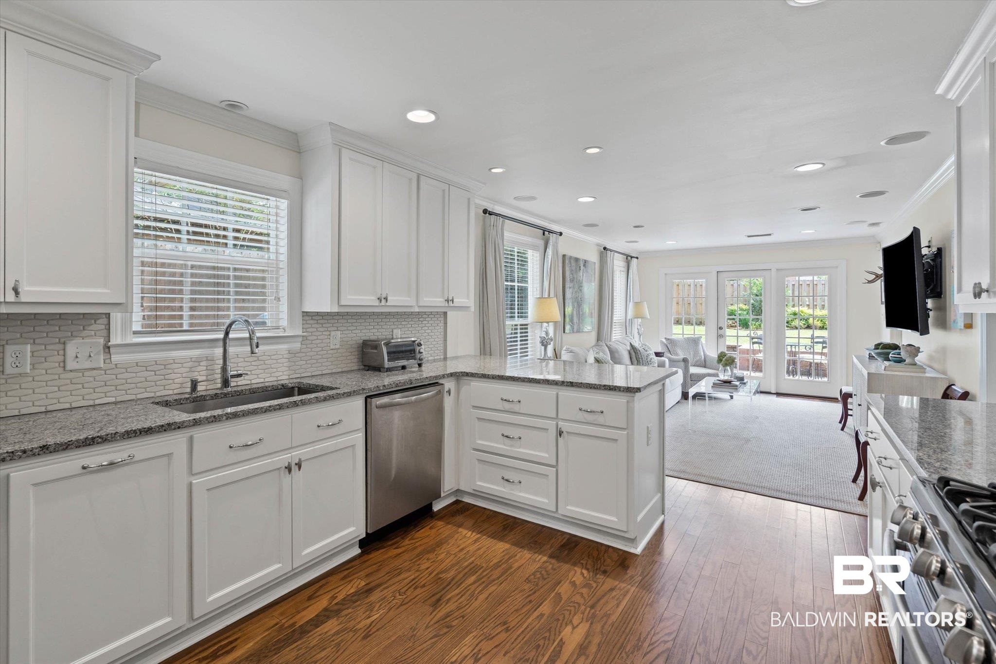 77 North Hathaway Road Mobile, AL 36608 - Photo 32 of 33 Kitchen featuring a peninsula, light stone counters, white cabinetry, open floor plan, and appliances with stainless steel finishes