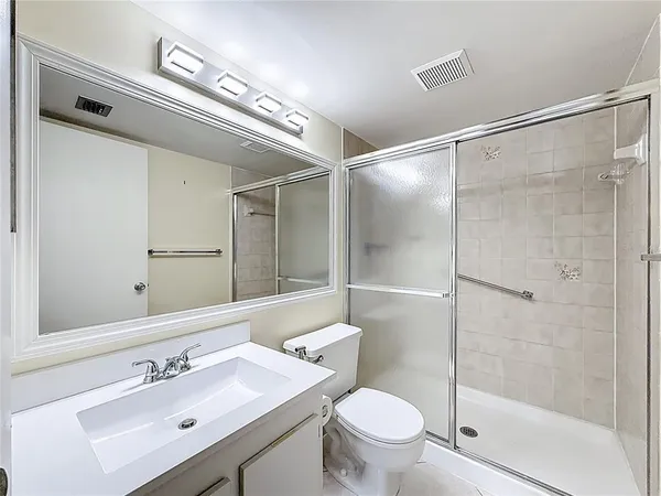 an empty room with windows and ceiling fan