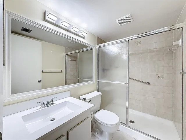 an empty room with windows and ceiling fan