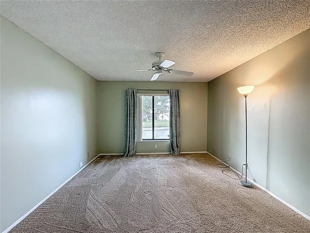 a view of a big room with chandelier fan and windows