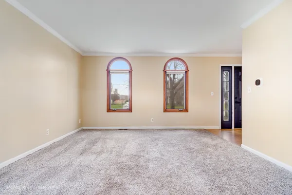 an empty room with windows and mirror
