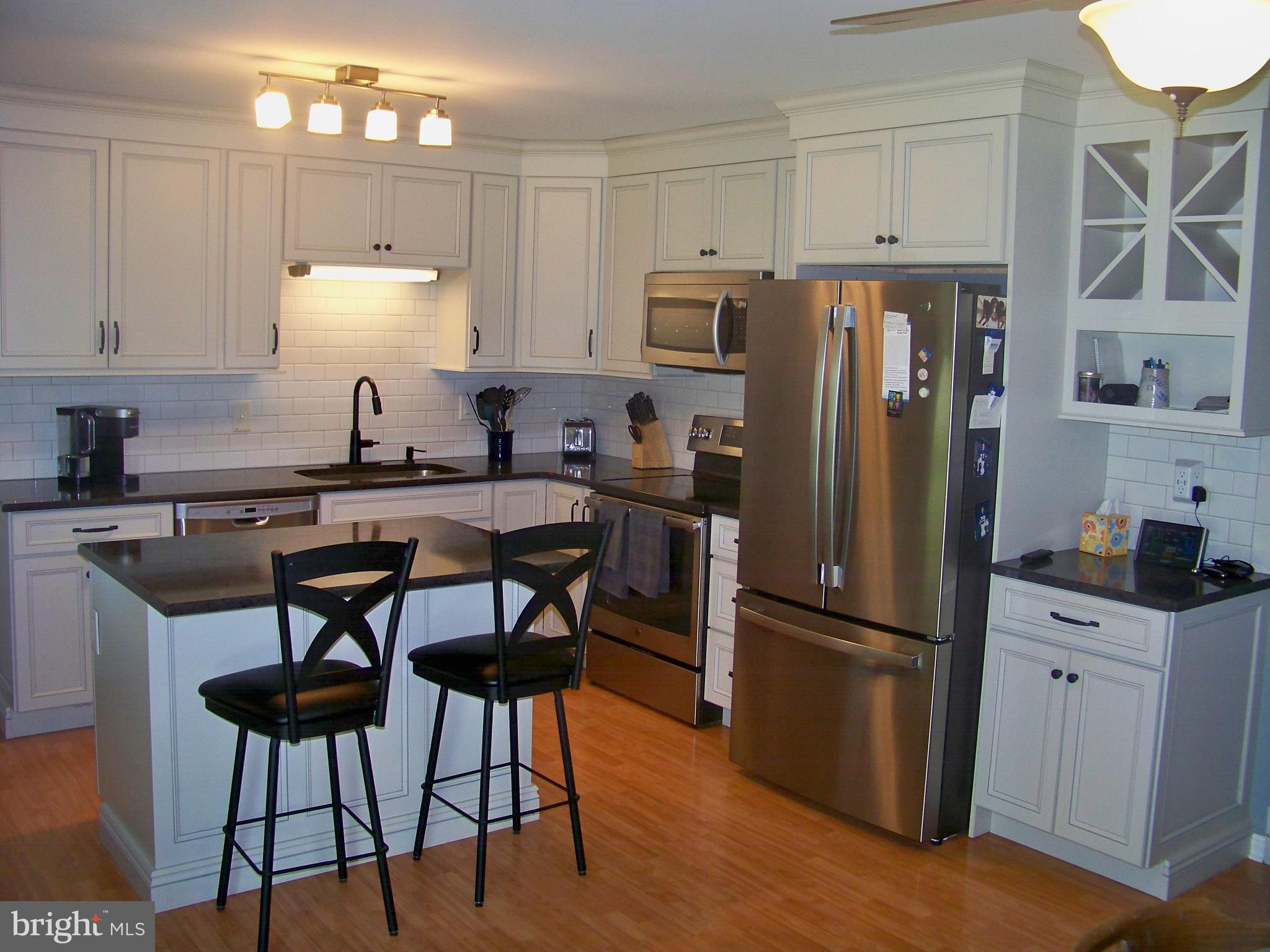 32 Green Acre Road Lititz, PA 17543 - Photo 7 of 21 a kitchen with stainless steel appliances a refrigerator a sink a stove a dining table and chairs